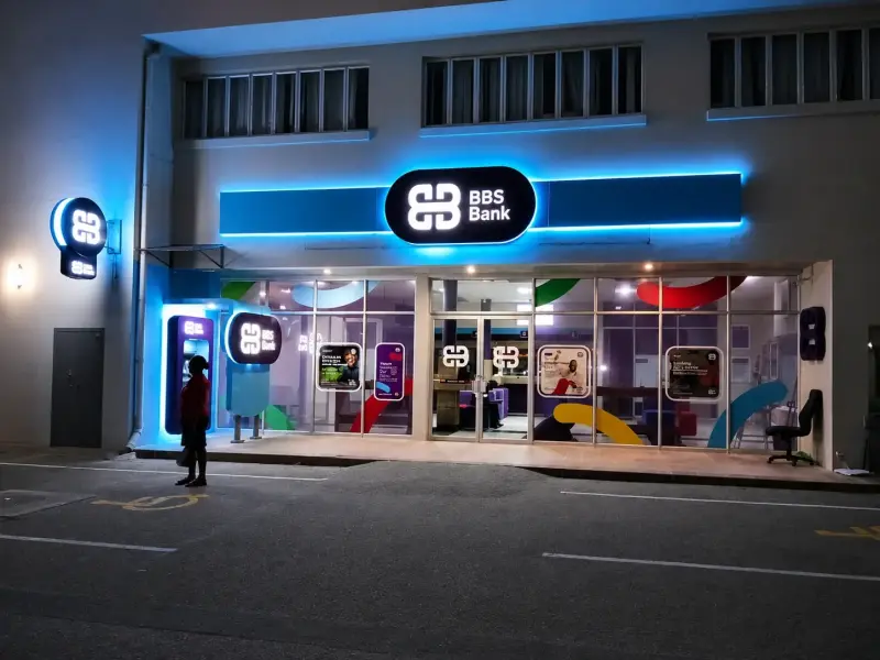 Illuminated BBS Bank branch frontage at night with backlit fascia and logo signs