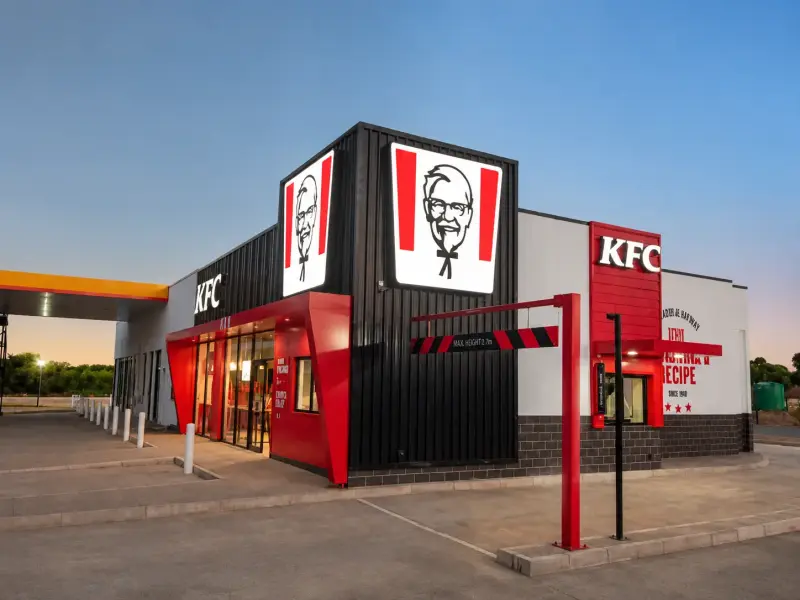 KFC restaurant exterior at dusk with illuminated logo and fascia signage