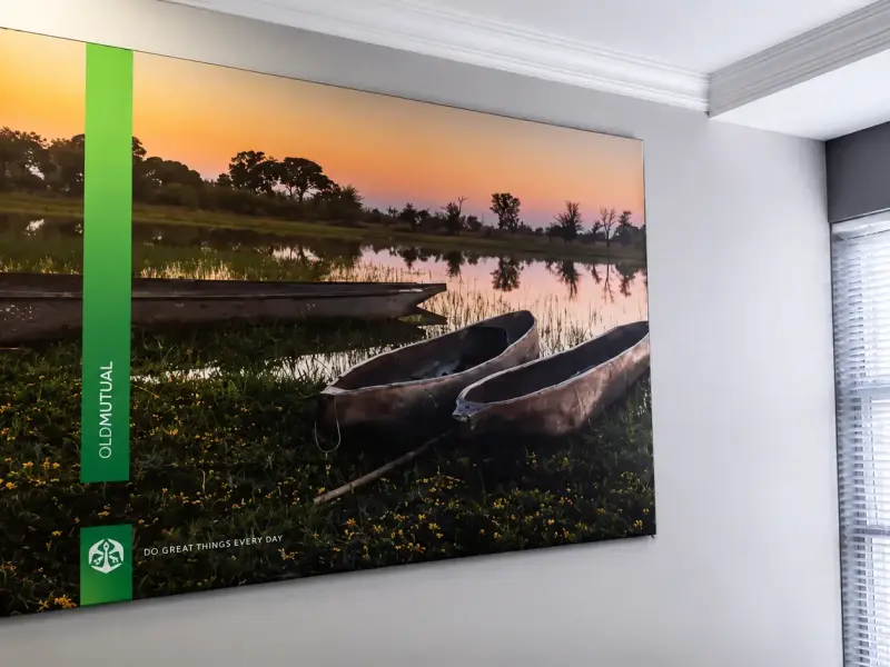 Framed Old Mutual wall print of mokoro canoes with the strapline Do great things every day