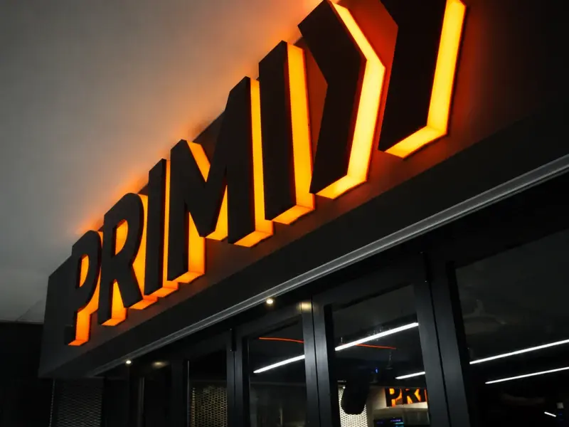 Halo-lit Primi letters on a restaurant frontage at night