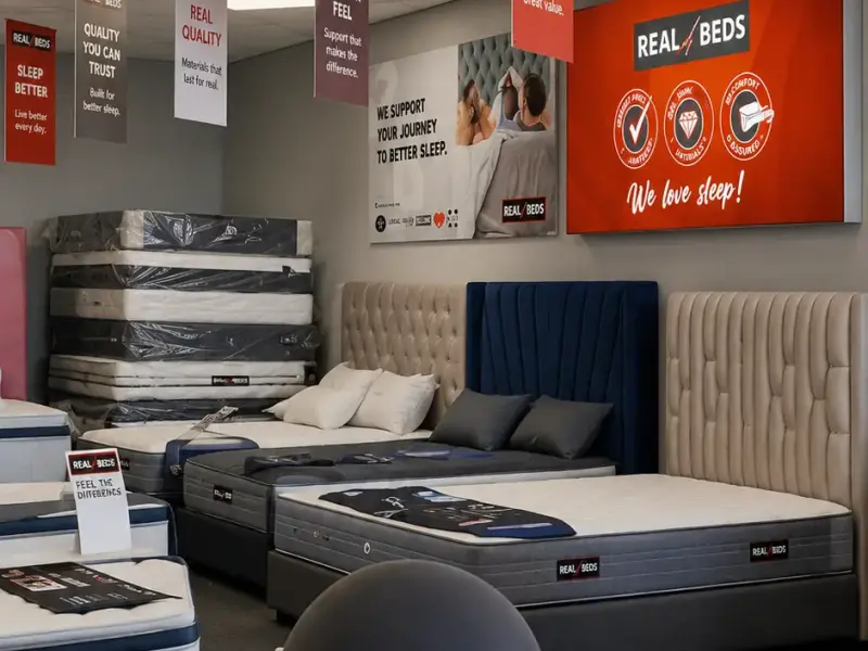 Real Beds store interior with branded wall panels reading We love sleep
