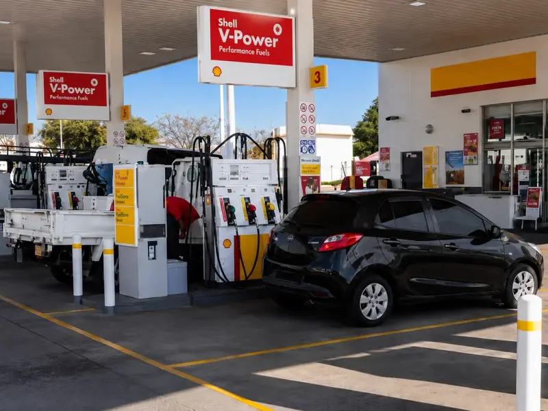 Forecourt bollard and pump signage at a Shell service station