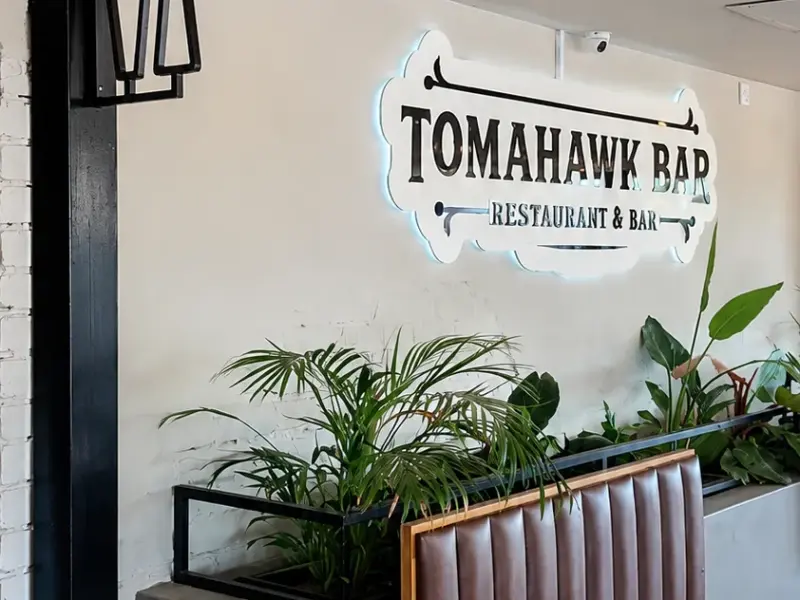 Tomahawk Bar restaurant interior sign above banquette seating