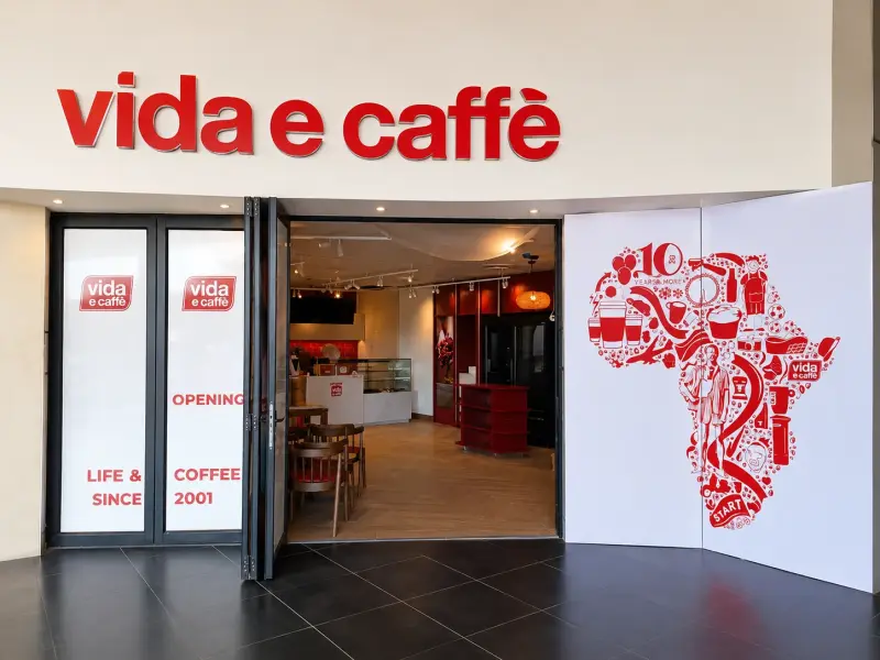 vida e caffe shopfront with fascia sign and printed Africa-map wall graphic